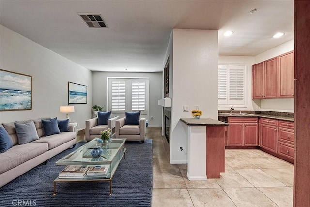 living room with recessed lighting, visible vents, light tile patterned floors, baseboards, and a fireplace