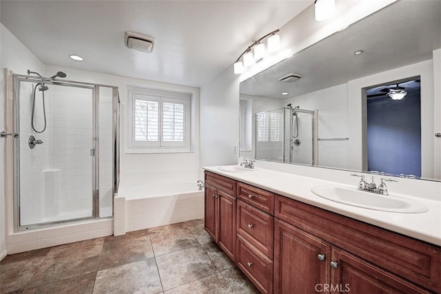 bathroom with a garden tub, a sink, double vanity, and a stall shower