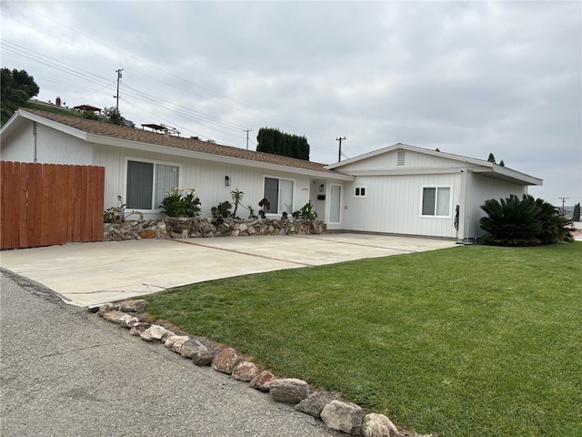 rear view of house featuring fence and a yard