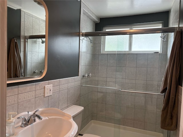 full bathroom with a stall shower, toilet, and a sink