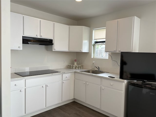 kitchen featuring fridge, a sink, under cabinet range hood, black electric cooktop, and light countertops