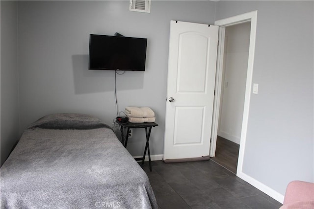 bedroom with baseboards, visible vents, and dark tile patterned floors