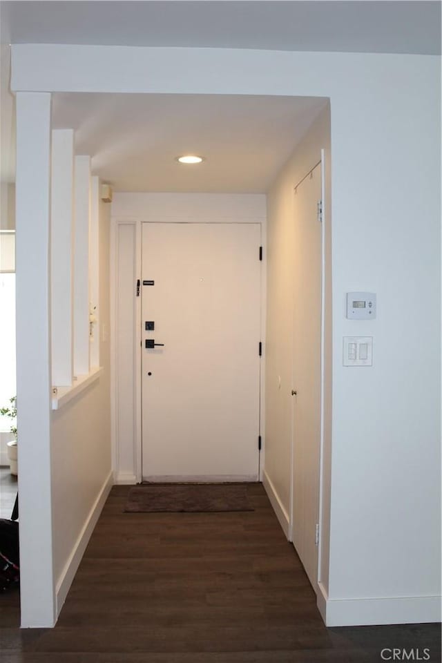 hallway featuring dark wood-style floors, baseboards, and recessed lighting