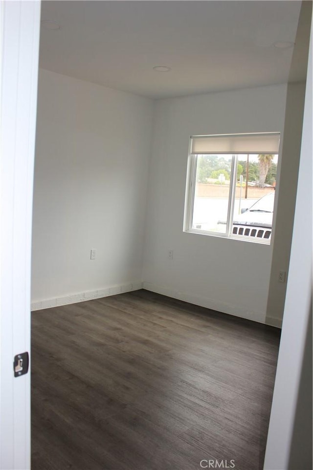 unfurnished room featuring wood finished floors and baseboards