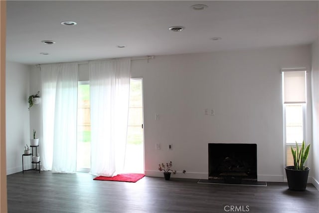 unfurnished living room featuring dark wood finished floors and baseboards
