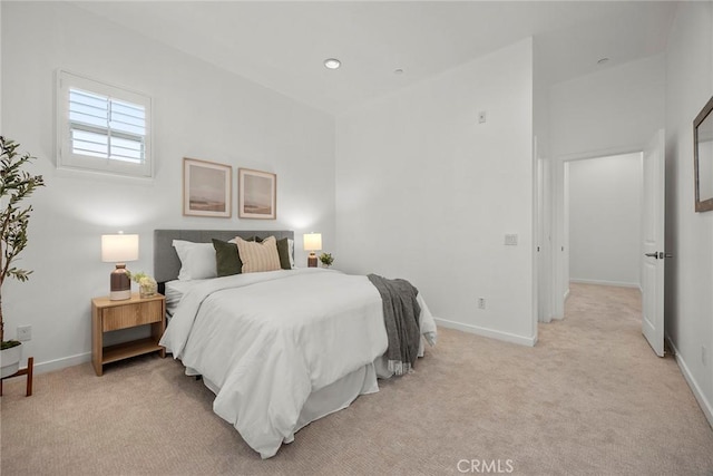 bedroom with baseboards and light carpet