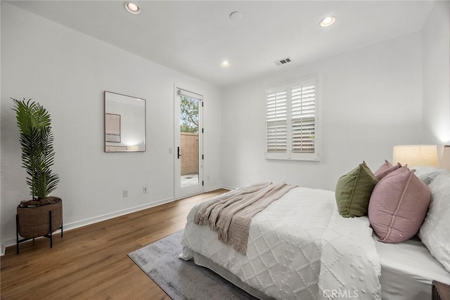 bedroom with wood finished floors, baseboards, access to outside, visible vents, and recessed lighting