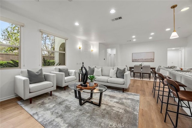 living room featuring wood finished floors, visible vents, and recessed lighting