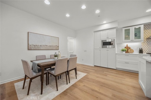 dining room featuring recessed lighting, light wood-style flooring, and baseboards