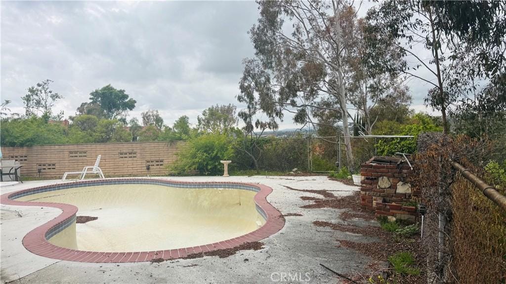 view of swimming pool with an empty pool, a patio area, and a fenced backyard