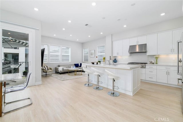 102 Pattern, Irvine, CA 92618 - kitchen with white cabinets, open floor plan, under cabinet range hood, and light wood-type flooring