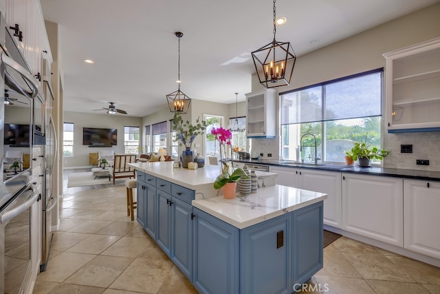 44 Water Lily Way, Coto De Caza, CA 92679 - kitchen featuring white cabinets, decorative backsplash, a sink, and blue cabinetry