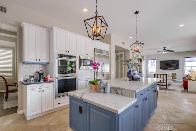 44 Water Lily Way, Coto De Caza, CA 92679 - kitchen featuring built in appliances, white cabinets, hanging light fixtures, and a kitchen island
