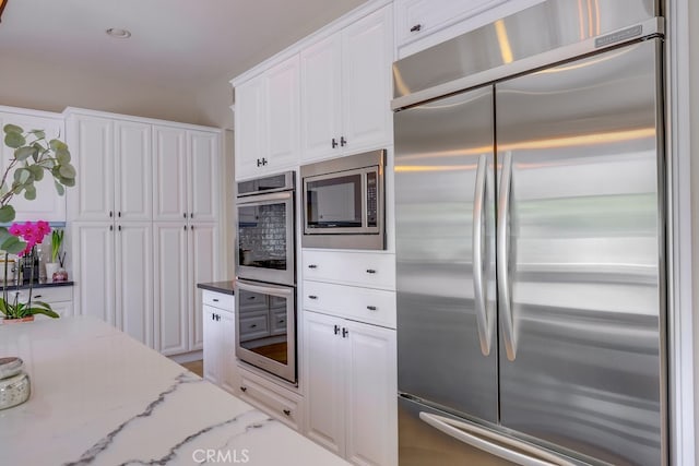 44 Water Lily Way, Coto De Caza, CA 92679 - kitchen featuring white cabinets, light stone countertops, and built in appliances