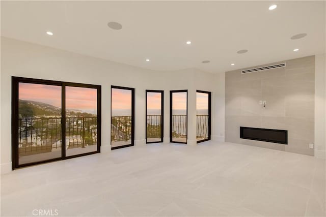 unfurnished living room with a fireplace, visible vents, tile patterned floors, and recessed lighting