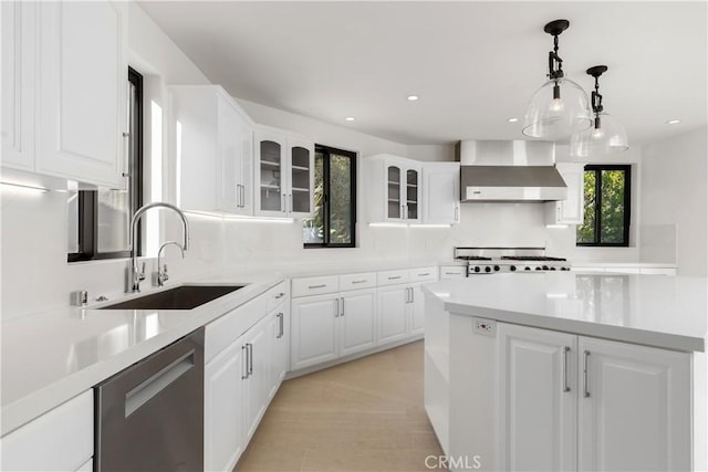 kitchen with stainless steel dishwasher, glass insert cabinets, a sink, wall chimney exhaust hood, and stove