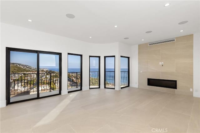 unfurnished living room featuring tile walls, recessed lighting, a tile fireplace, and light tile patterned flooring