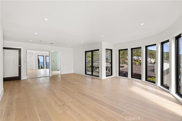 unfurnished room with baseboards, recessed lighting, and light wood-style flooring