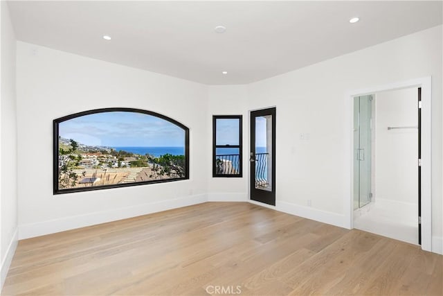 unfurnished room featuring recessed lighting, light wood-style flooring, and baseboards