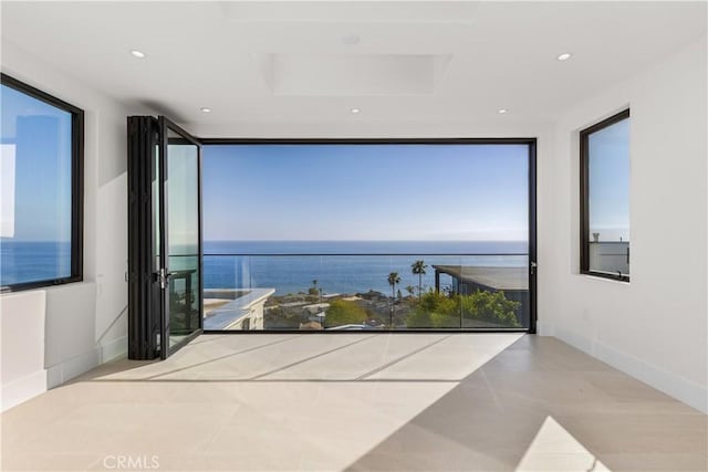 interior space with recessed lighting, a water view, and plenty of natural light