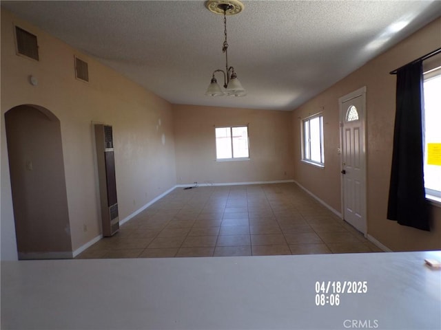 74813 Sunrise Dr Unit 29, Palms, CA 92277 - tiled entrance foyer with a heating unit, a chandelier, arched walkways, baseboards, and a textured ceiling