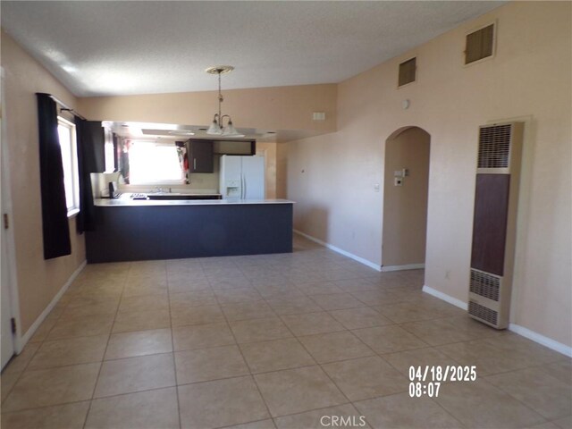 74813 Sunrise Dr Unit 29, Palms, CA 92277 - kitchen featuring white refrigerator with ice dispenser, a heating unit, lofted ceiling, a peninsula, and light countertops