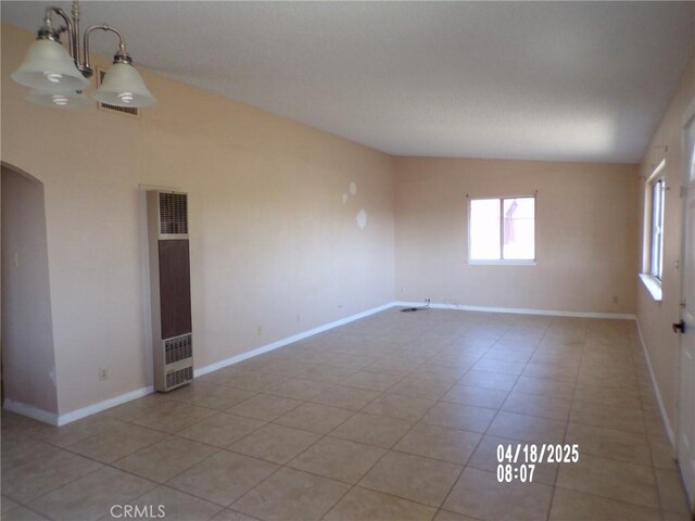 74813 Sunrise Dr Unit 29, Palms, CA 92277 - unfurnished room with a heating unit, plenty of natural light, light tile patterned floors, baseboards, and vaulted ceiling