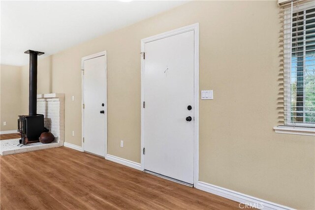 14306 Boxtree St, Lake Hughes, CA 93532 - interior space with baseboards, wood finished floors, and a wood stove