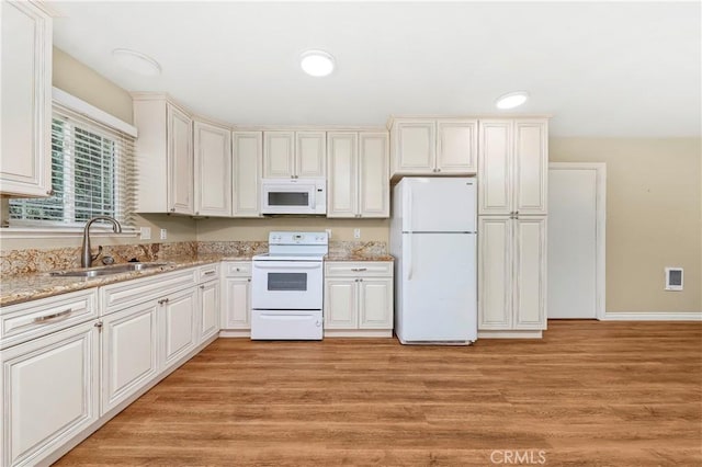 14306 Boxtree St, Lake Hughes, CA 93532 - kitchen with light wood-type flooring, light stone countertops, white appliances, and a sink