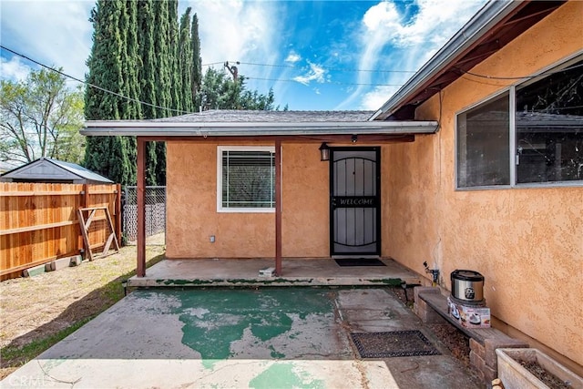 14306 Boxtree St, Lake Hughes, CA 93532 - view of exterior entry with stucco siding, fence, and a patio