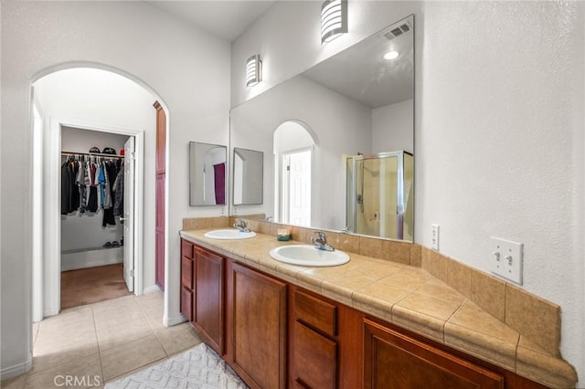 7625 Pinon Dr, Yucca Valley, CA 92284 - full bath featuring a stall shower, double vanity, a spacious closet, and tile patterned flooring