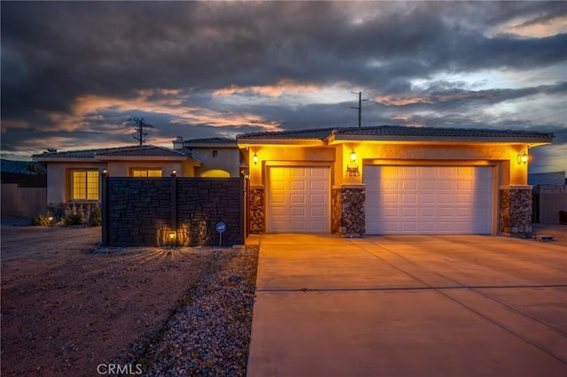 7625 Pinon Dr, Yucca Valley, CA 92284 - view of front of property featuring a garage, stucco siding, stone siding, concrete driveway, and a tile roof