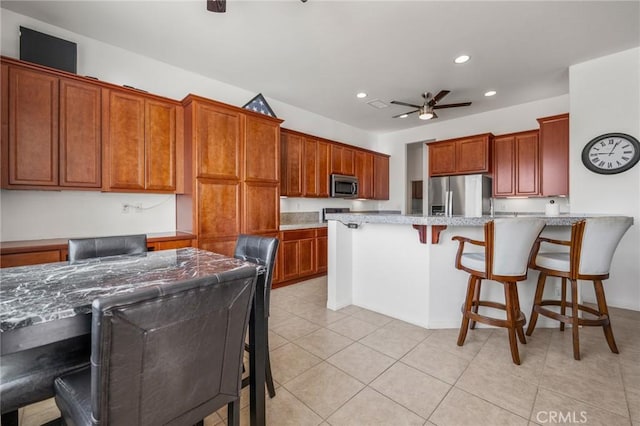7625 Pinon Dr, Yucca Valley, CA 92284 - kitchen with stainless steel appliances, recessed lighting, a ceiling fan, a kitchen breakfast bar, and a peninsula