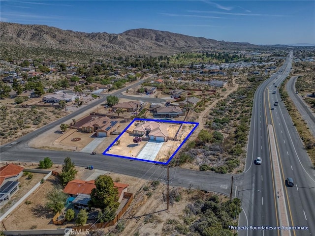 7625 Pinon Dr, Yucca Valley, CA 92284 - aerial view of residential area with property parcel outlined and a mountain backdrop