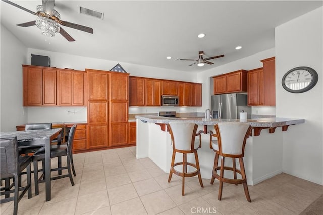 7625 Pinon Dr, Yucca Valley, CA 92284 - kitchen featuring appliances with stainless steel finishes, a ceiling fan, brown cabinets, recessed lighting, and a peninsula