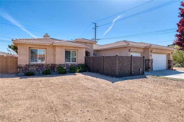 7625 Pinon Dr, Yucca Valley, CA 92284 - view of front facade with stone siding, stucco siding, concrete driveway, and an attached garage