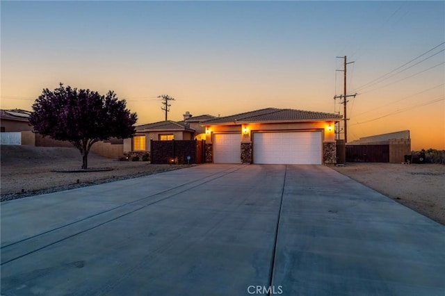 7625 Pinon Dr, Yucca Valley, CA 92284 - view of front of property with an attached garage, stucco siding, concrete driveway, a tile roof, and a chimney