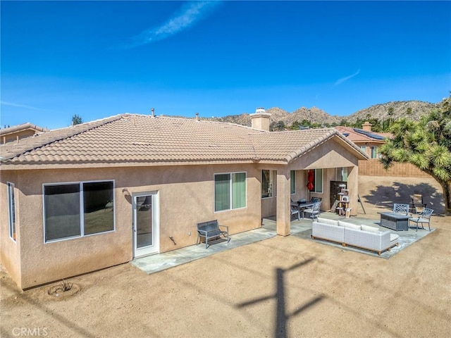 7625 Pinon Dr, Yucca Valley, CA 92284 - rear view of house featuring a chimney, stucco siding, a patio area, a tiled roof, and a mountain view