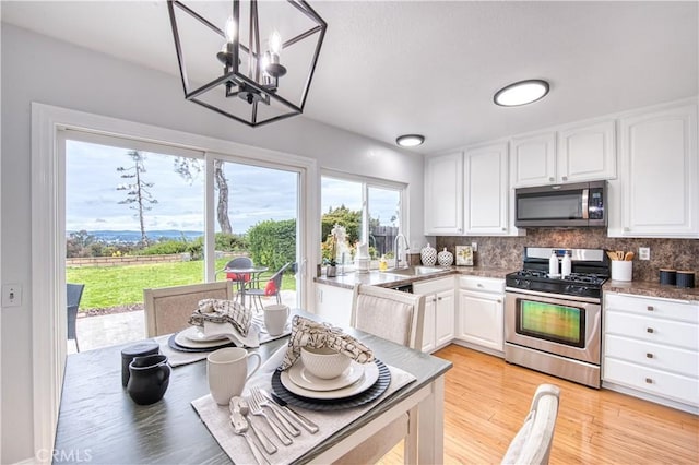 22911 Via Santiago, Mission Viejo, CA 92691 - kitchen with white cabinetry, stainless steel appliances, backsplash, and a sink