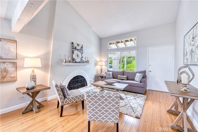 22911 Via Santiago, Mission Viejo, CA 92691 - living area featuring a brick fireplace, high vaulted ceiling, wood finished floors, and baseboards