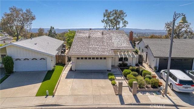 22911 Via Santiago, Mission Viejo, CA 92691 - view of front of property with a garage, a mountain view, a chimney, concrete driveway, and fence