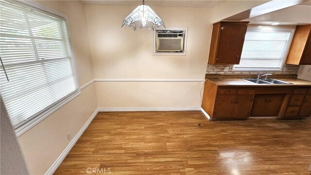 1060 Newhill St, Glendora, CA 91741 - kitchen featuring wood finished floors, a wall unit AC, baseboards, and a sink
