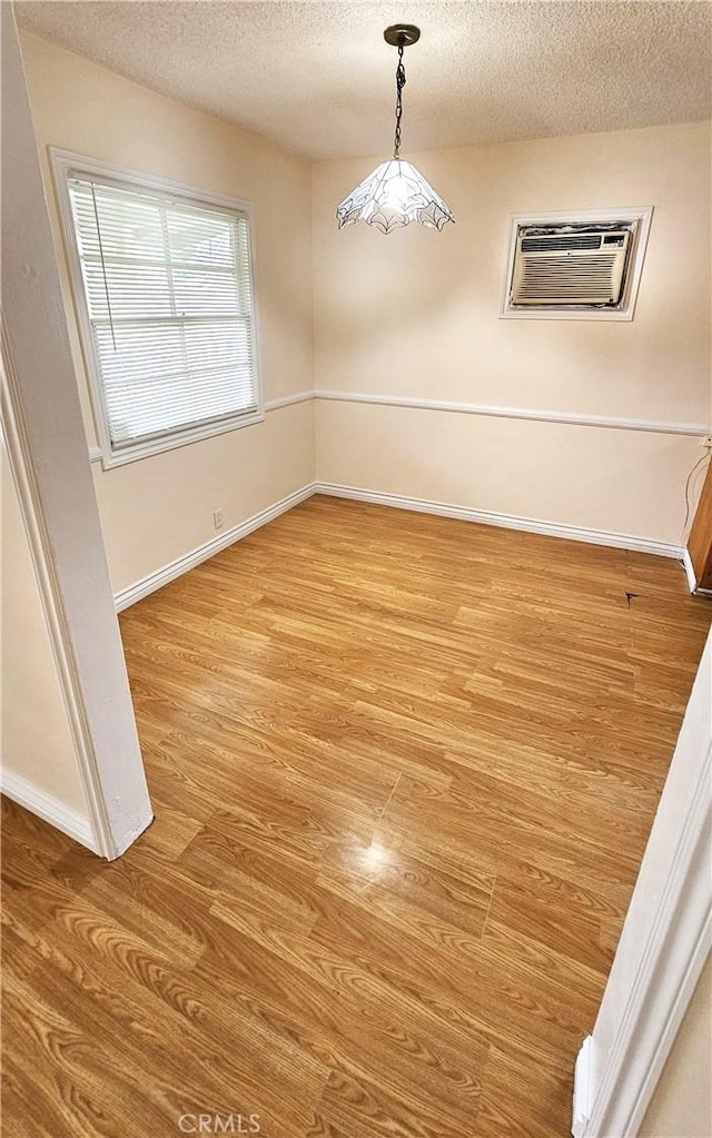 1060 Newhill St, Glendora, CA 91741 - unfurnished dining area featuring baseboards, a wall mounted air conditioner, wood finished floors, and a textured ceiling