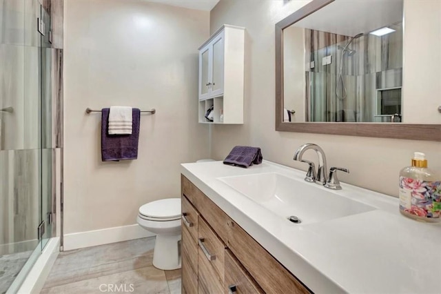 bathroom featuring a shower stall, tile patterned floors, toilet, vanity, and baseboards