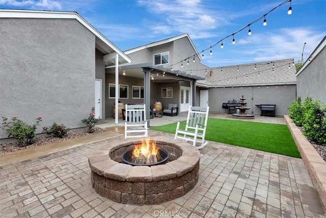 view of patio / terrace with a fire pit and a grill