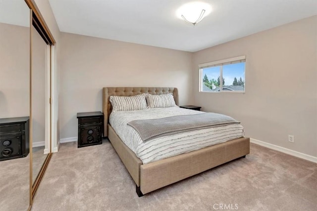 carpeted bedroom with baseboards and a closet