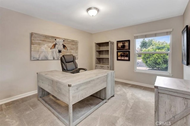 office with baseboards and light carpet