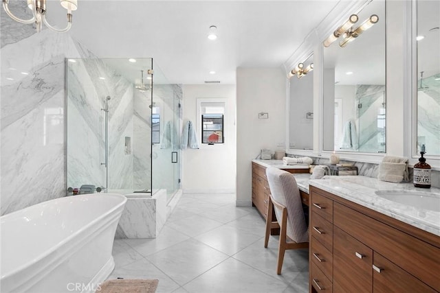 full bath with a marble finish shower, vanity, a soaking tub, baseboards, and a notable chandelier