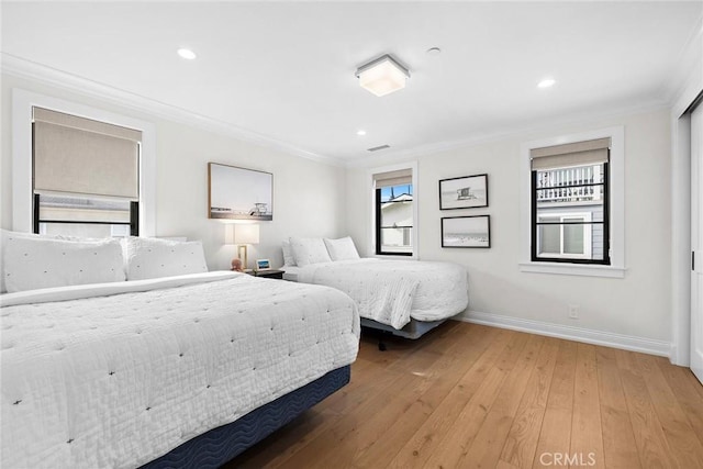 bedroom featuring hardwood / wood-style floors, baseboards, recessed lighting, and ornamental molding