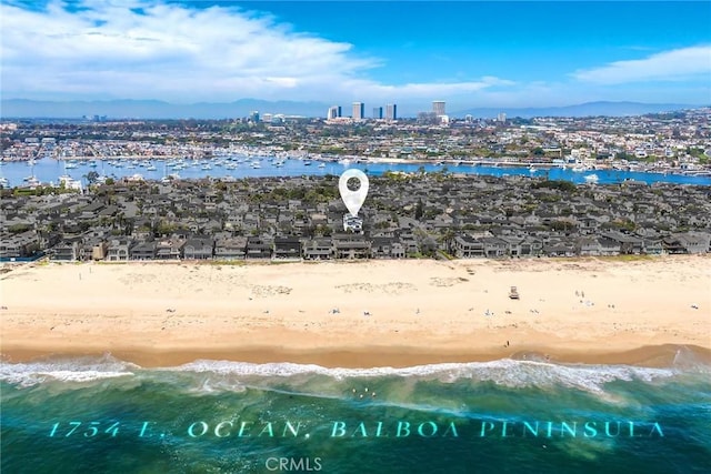 aerial view with a beach view, a water view, and a view of city